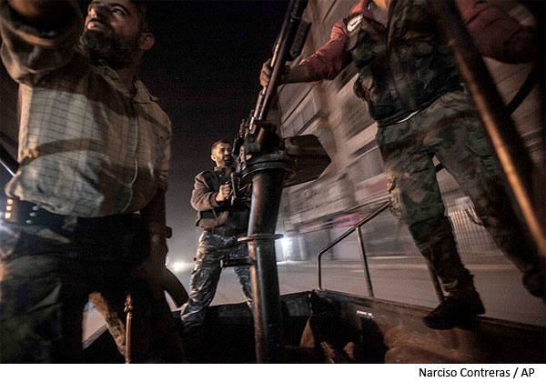 A mobile rebel unit with a truck-mounted gun moves through rebel-held streets. Syria.